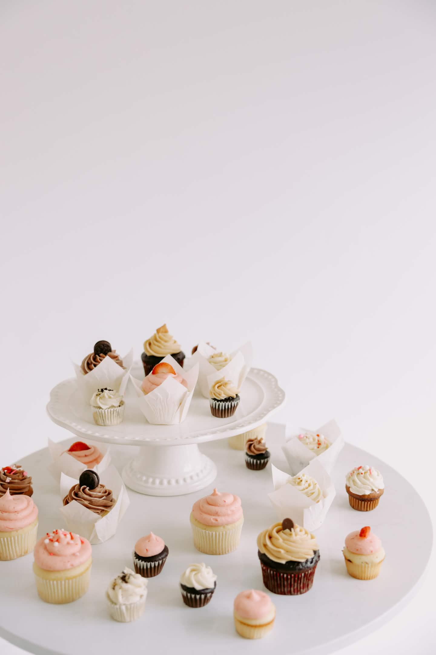 Assorted cupcakes on a white cake stand